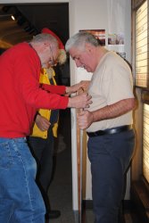 Jon Habegger and Mark Gellman work to get the plexiglass into the stained frame