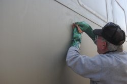 Kevin Kriebs removing adhesive on 1st Exhibit Car exterior