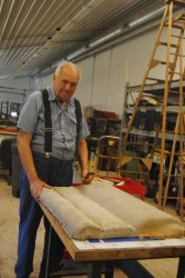 John McKelvey with a stripped down DM&IR 84 coach seat back in the Wood Shop - Photo by Shelly Vanderschaegen