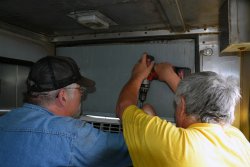 Michael Baksic and Mark Gellman installing AC - Photo by Jon Habegger 