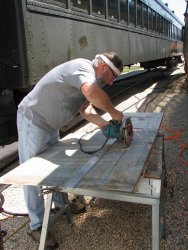 Chuck uses a straight edge to cut the metal replacement - Photo by Pauline Trabert