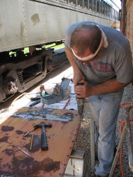 The old door cover is used to mark the new holes to be drilled - Photo by Pauline Trabert 