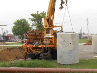 Setting concrete pipe into hole.