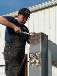 Volunteer Stu tightens the bolts on the top bearing of the table after the installation of the support beams