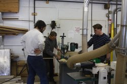 Richard Schauer, Tim Peters and Bill Moran work on running the wood planks through the router for the roof of the 8002 - 01/22/2011.