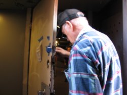 Wayne Baksic fixing a door lock in the 2nd Exhibit car.