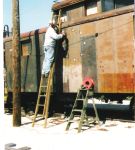 09.10.04 - THE LEFT SIDE OF THE CAR HAS BEEN NEEDLE CHIPPED TO REMOVED THE OLD PAINT.  KIRK WARNER IS WIRE WHEELING THE METAL PRIOR TO APPLYING PRIMER.