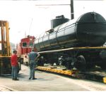 THE CAR IS SLOWLY MOVED OFF OF THE TRAILER WITH THE CORNWALL ENGINE BEING USED TO STOP THE CAR IF IT MOVES TOO QUICKLY.  BOB KUTELLA AND JEFF DELLHAYE OBSERVE IWTH INTEREST.