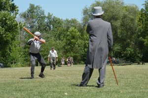 Vintage baseball game with umpire in top hat.