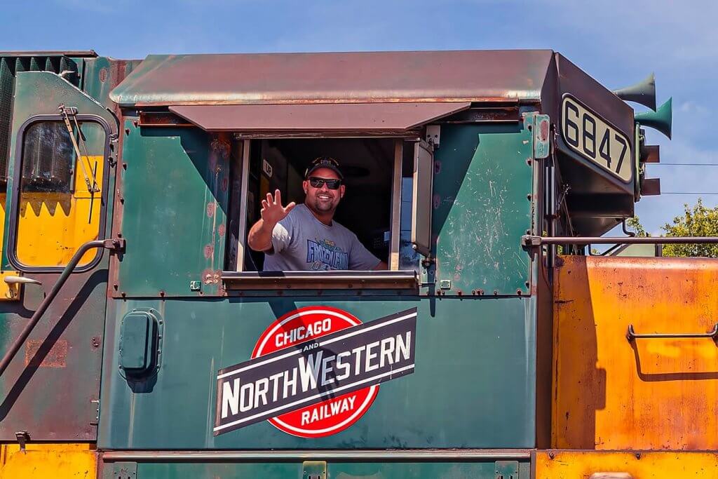 Guest engineer operating a Chicago & North Western Railway SD40-2 diesel locomotive during a "Take the Throttle" event at the Illinois Railway Museum.